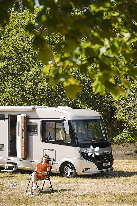中年妇女在拖车公园的房车旁椅子上放松图片素材