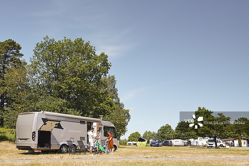 在拖车公园，一家人在露营车旁摆放椅子图片素材