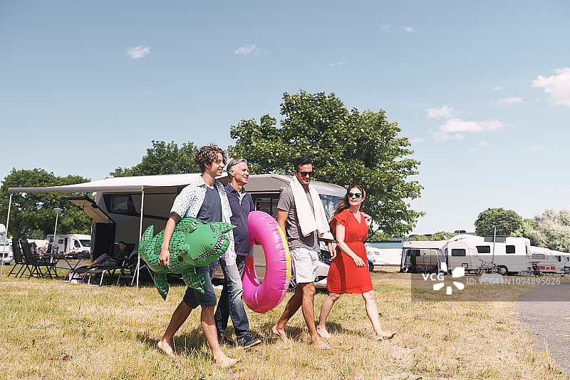 一家人带着充气游泳圈走在草地上图片素材