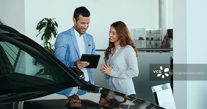 与顾客交谈的汽车销售员图片素材