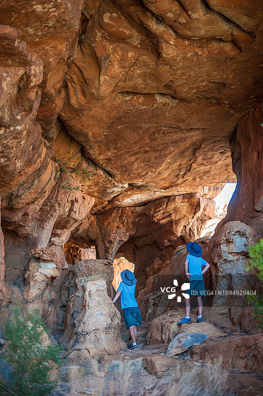 两个男孩在砂岩洞穴里观看图片素材