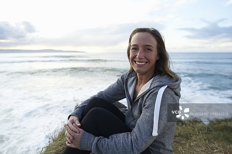 在海滩上穿运动帽衫的快乐女人图片素材