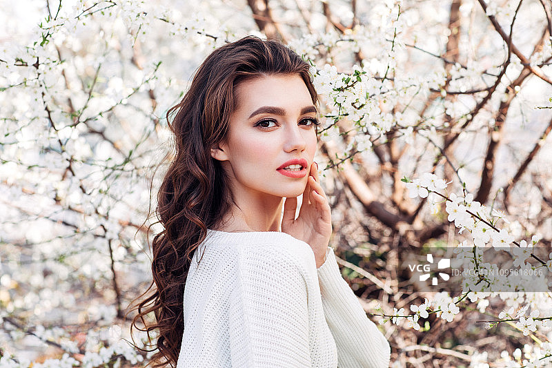 春天灌木丛背景上的美丽女孩图片素材