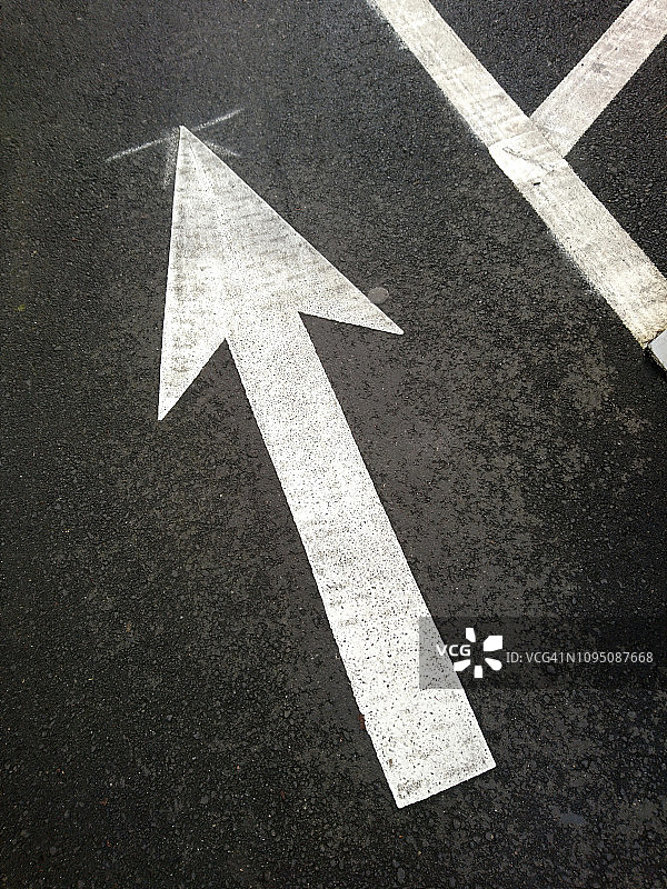 铺砌的街道上绘制的白色指向箭头图片素材