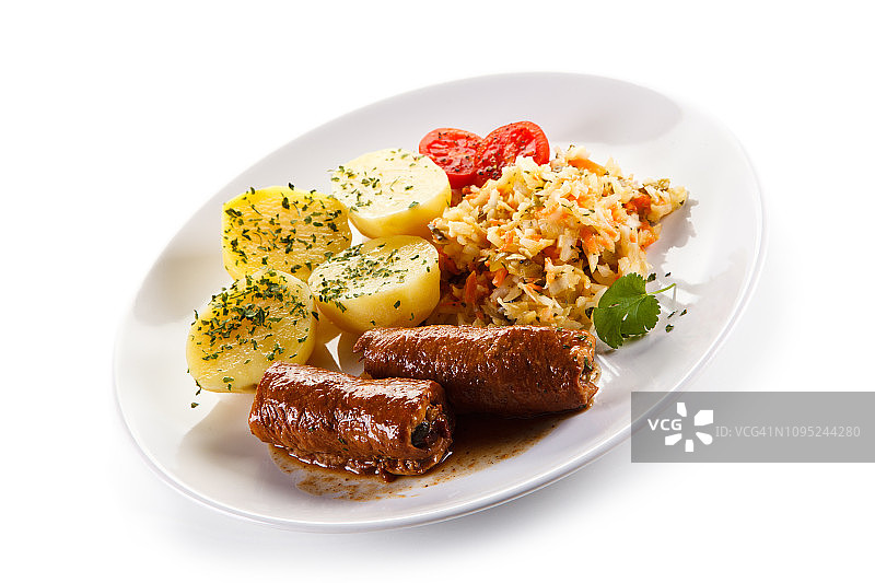 白底上的猪肉卷、煮土豆和蔬菜沙拉图片素材