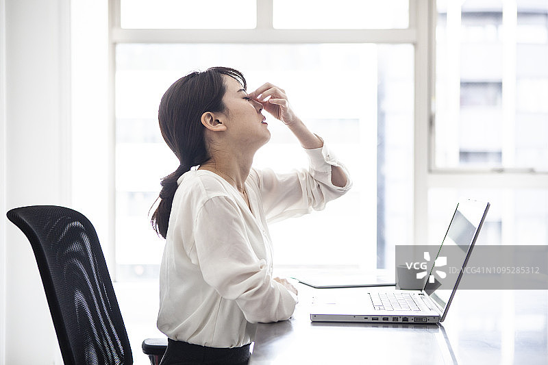 疲惫的女员工在坚持工作图片素材