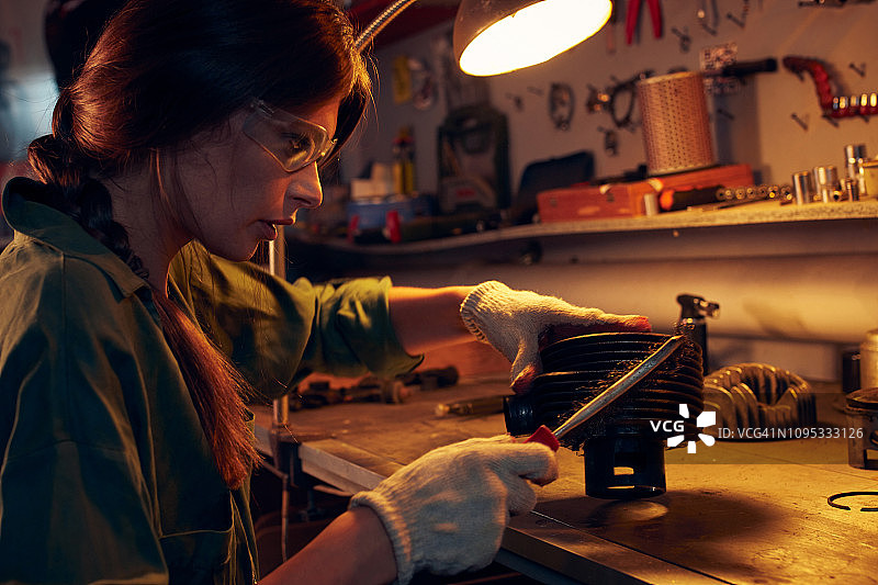 女人在车间清洁摩托车气缸图片素材
