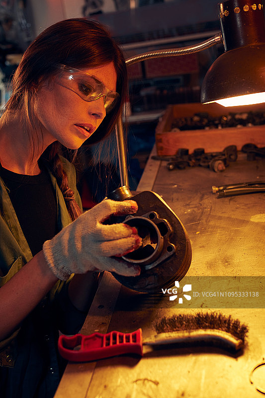 女人在车间清洁摩托车气缸图片素材