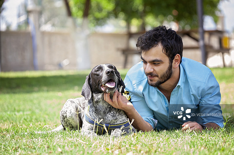 年轻人与猎犬在户外玩耍图片素材