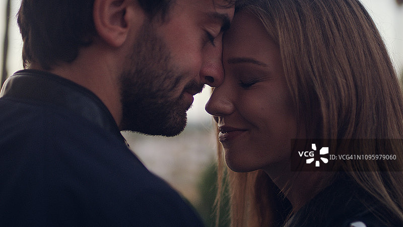 情侣依偎在一起站在老城区，日落图片素材