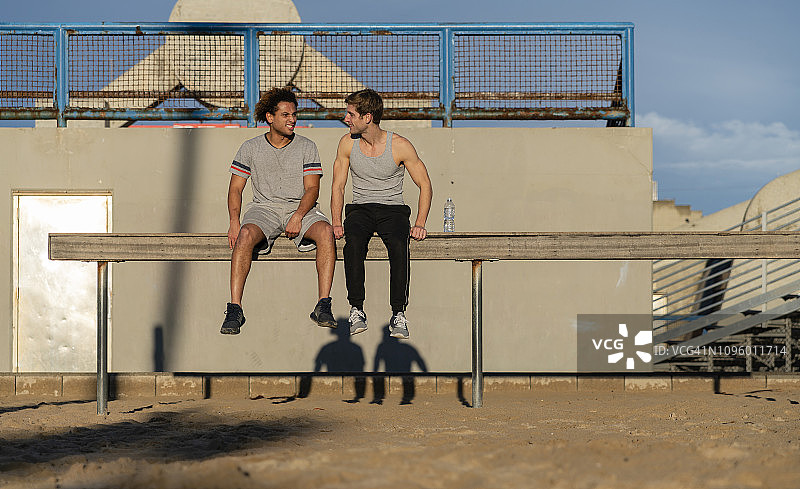 两位年轻的朋友在肌肉海滩运动区休息图片素材