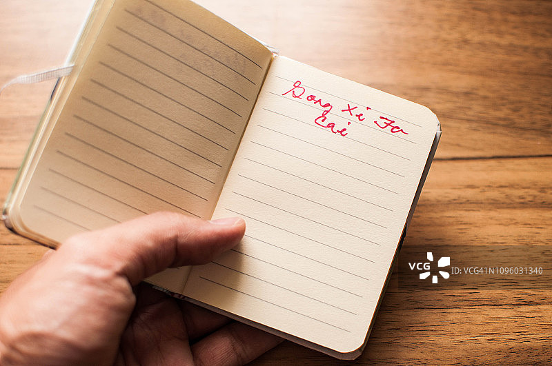 手拿写有“恭喜发财”字样的笔记本图片素材