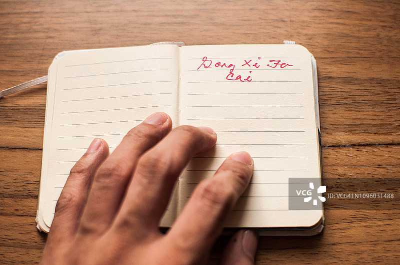 手拿写有“恭喜发财”字样的笔记本图片素材