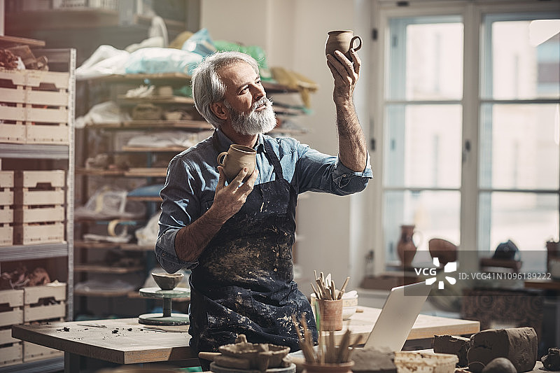 陶器作坊里的络腮胡老工匠图片素材