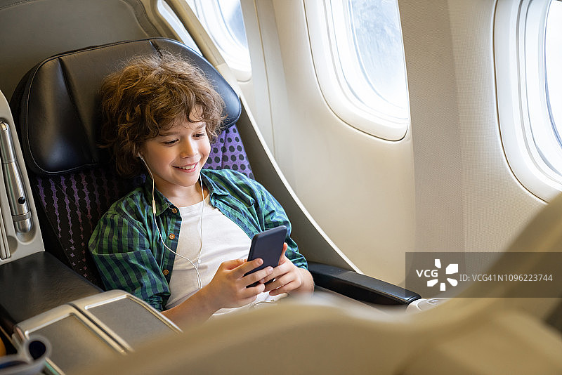 快乐的男孩乘飞机旅行听音乐图片素材