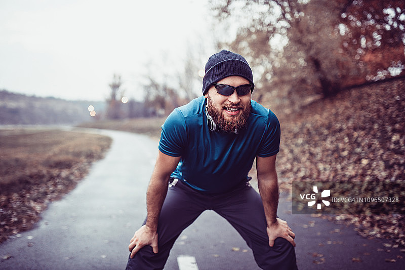 留着胡须的男运动员在有氧运动后休息图片素材