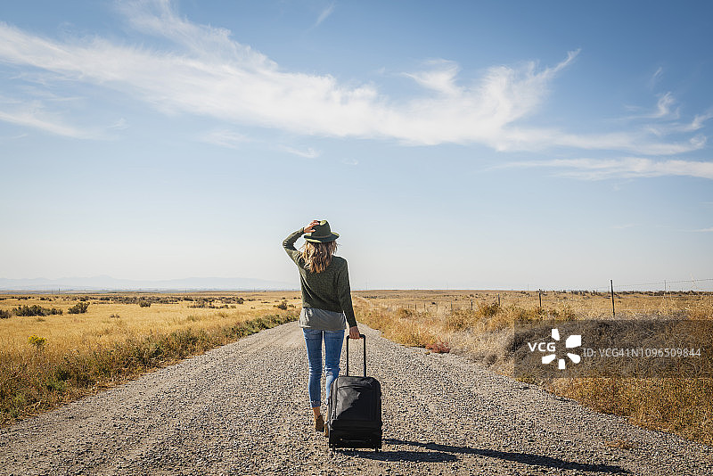 年轻女人在土路上行走图片素材