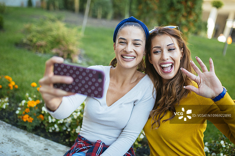 女人在城市公园自拍，面带微笑图片素材