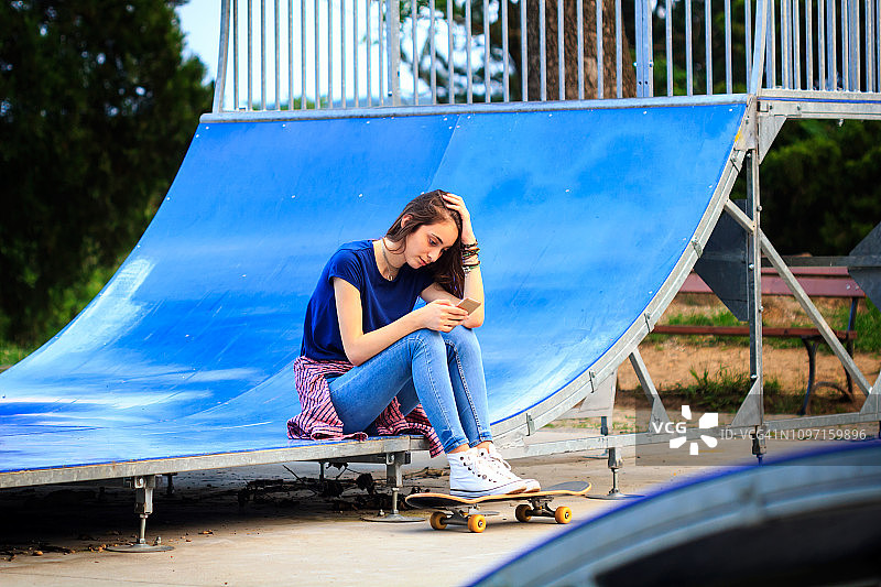 使用手机的滑板少女图片素材