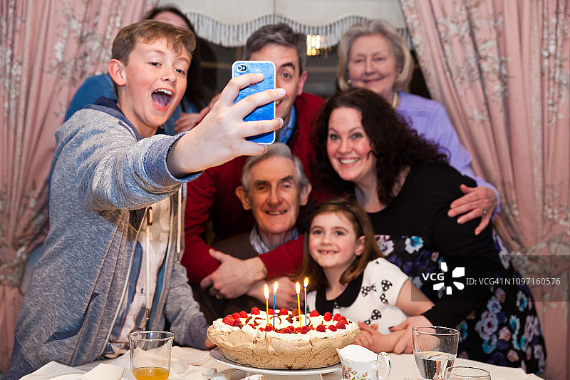 多代家庭在生日聚会上用手机自拍图片素材
