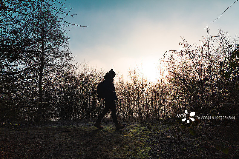 一个男人在冬日雾中日出时徒步旅行图片素材