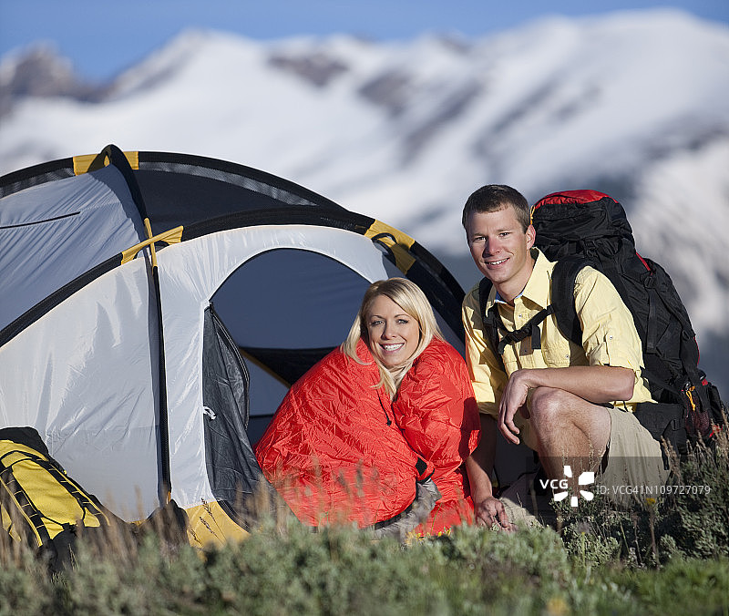 年轻情侣在山中露营，有帐篷和背包图片素材