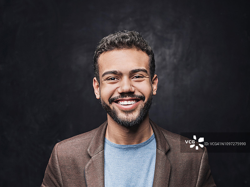 微笑的年轻男子工作室肖像照图片素材