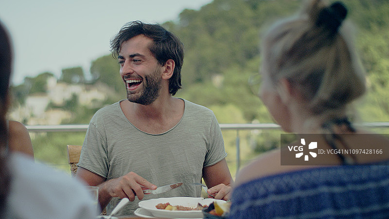 与朋友在庭院中享用晚餐图片素材