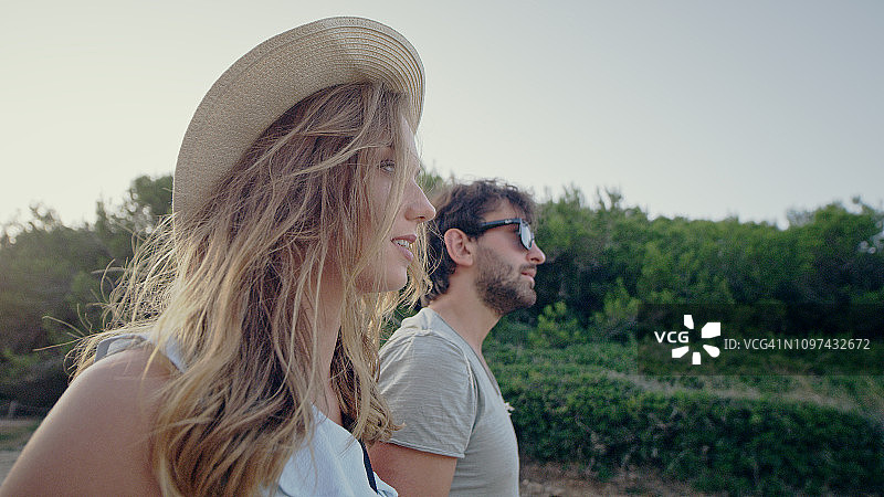 情侣沿着海滩散步，日落时分图片素材