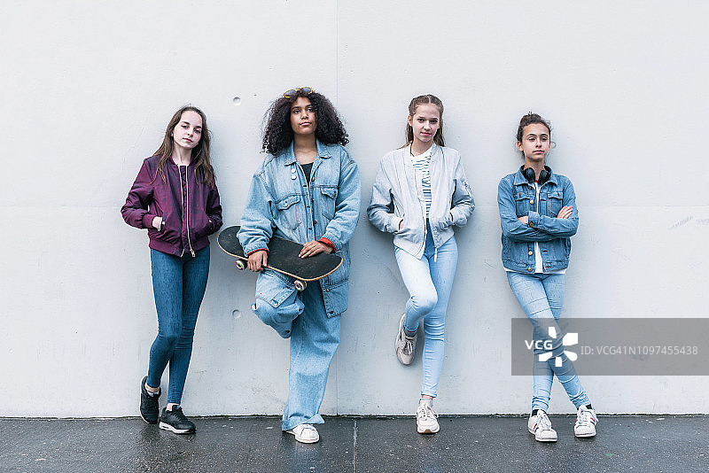 混凝土墙前的四个少女图片素材