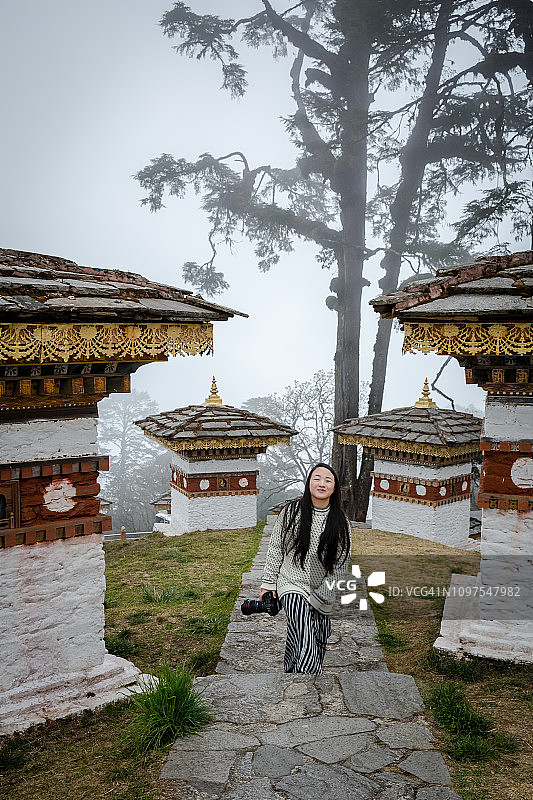 在不丹多雄拉山口参观佛塔的年轻女子图片素材