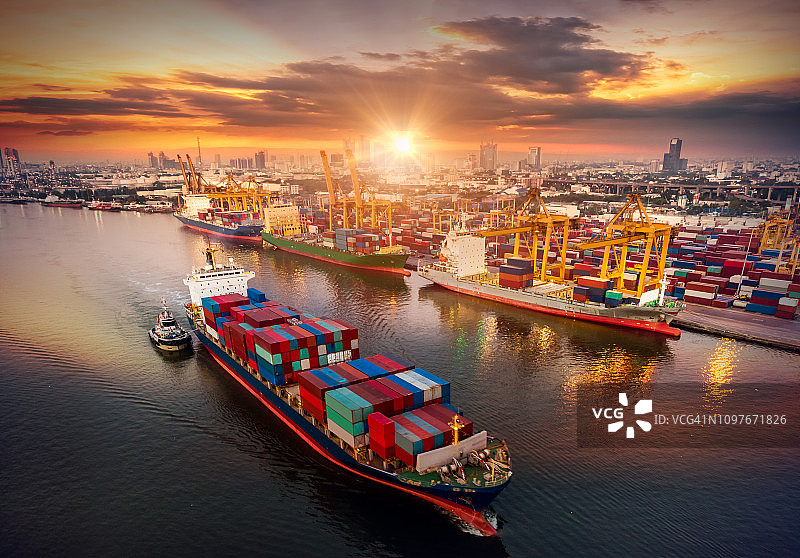 物流与运输的集装箱货轮和货机与工作起重机桥在日出船厂，物流进出口和运输行业背景图片素材