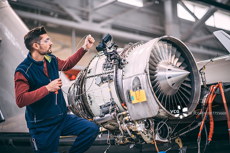 飞机工程师在机库中用摄像头探头维修和维护飞机喷气发动机图片素材