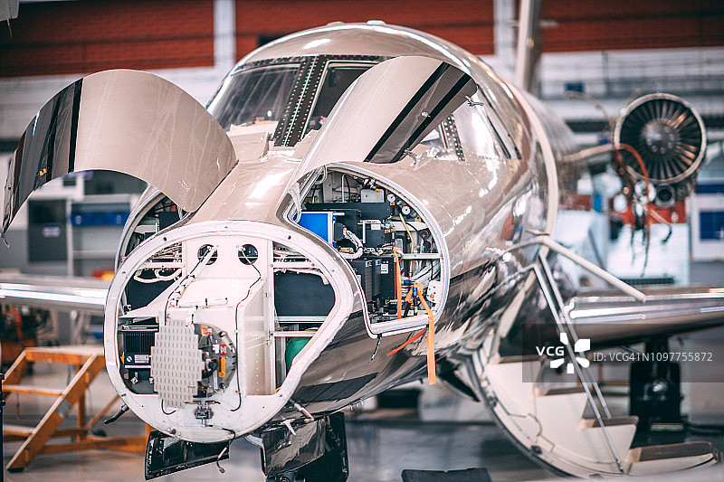 机库内拆卸的小型飞机，带有打开的发动机舱和无锥形罩图片素材