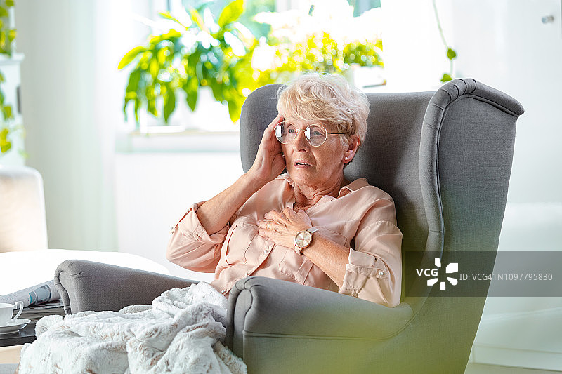 胸口疼痛的焦虑老年妇女图片素材