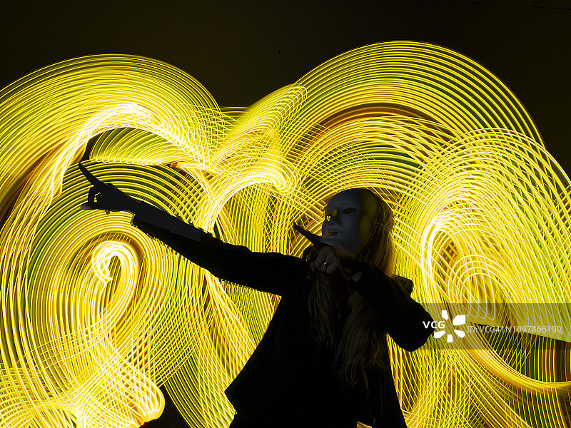 戴着面具、态度积极向上的女人，可能是庆祝的标志，未来主义环境图片素材