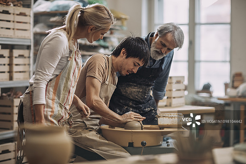 年轻男人在陶艺作坊制作陶罐图片素材