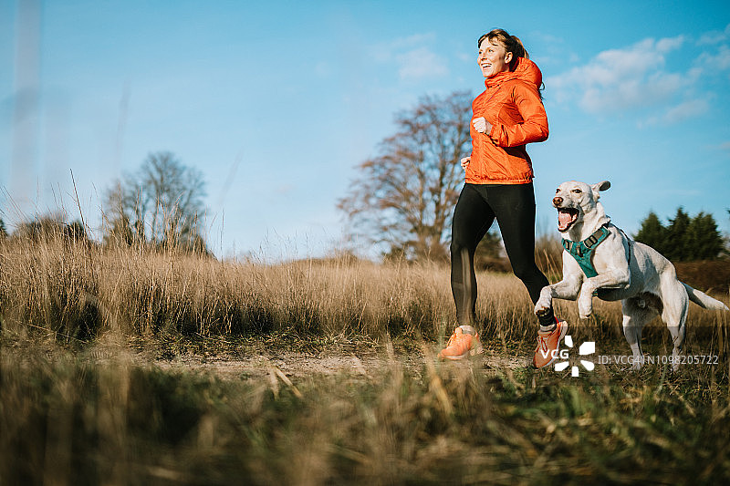 带着宠物狗在户外跑步的女人图片素材
