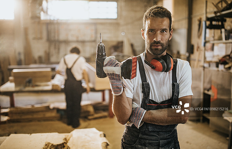 在木工车间手持钻头的体力劳动者肖像图片素材