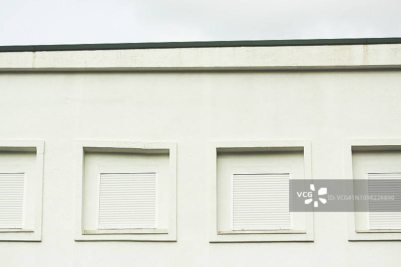 白色外墙上带百叶窗的紧闭窗户图片素材