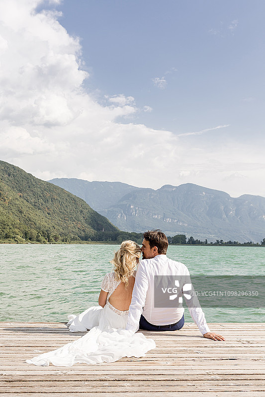坐在码头上美丽的新婚夫妇图片素材