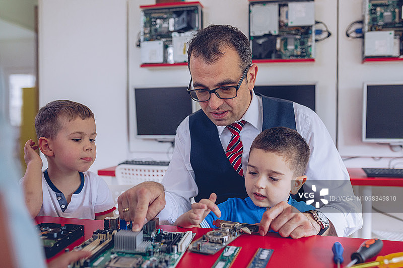 男孩和老师修理电脑硬件图片素材