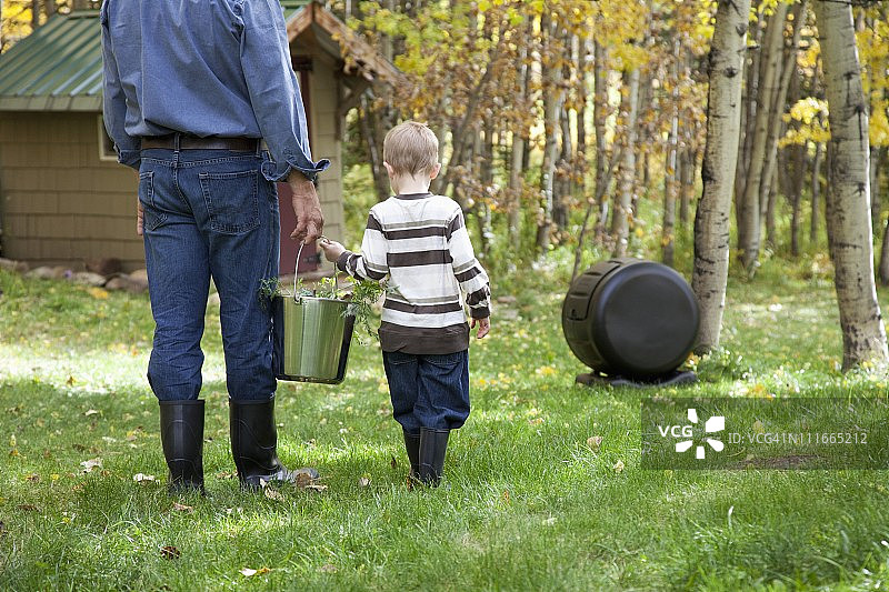 父亲与儿子搬运堆肥图片素材