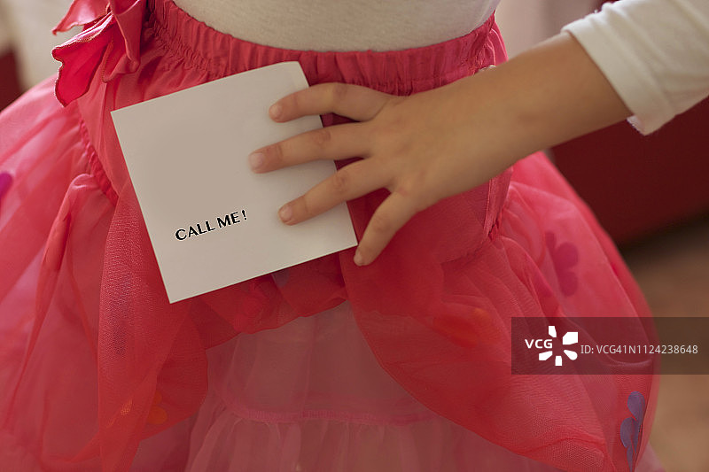 女孩手拿写有“Call Me”信息的纸图片素材
