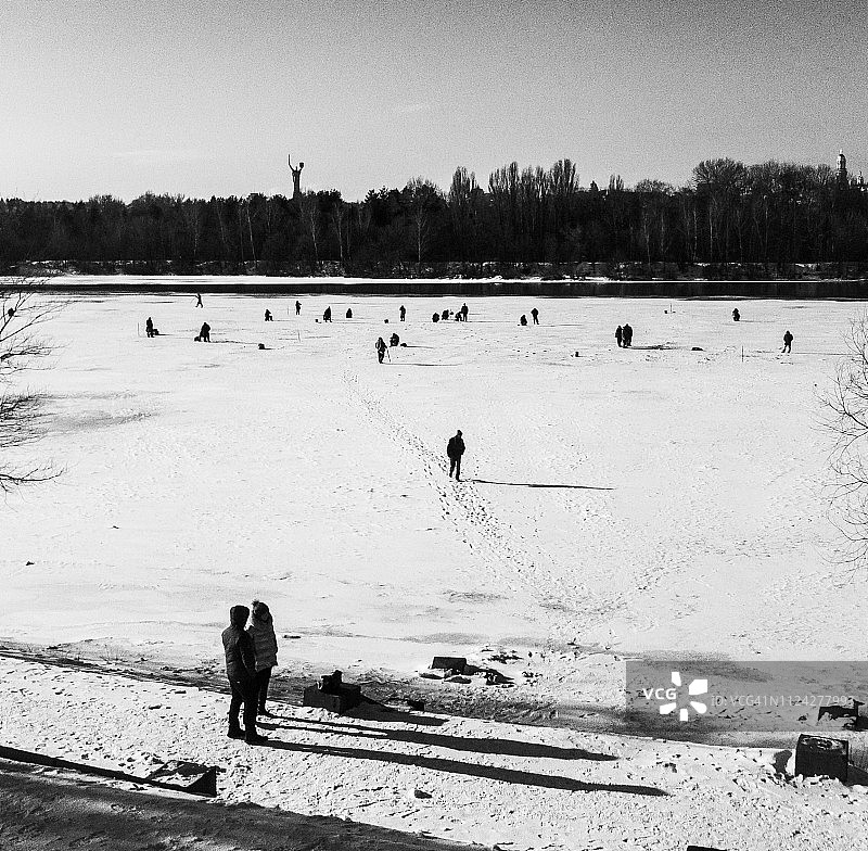 在冰冻的河面上冬钓的人们图片素材