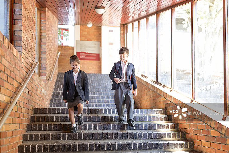 微笑的学生在学校的台阶上走下来图片素材