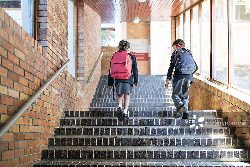 背着书包走上楼梯的学生图片素材