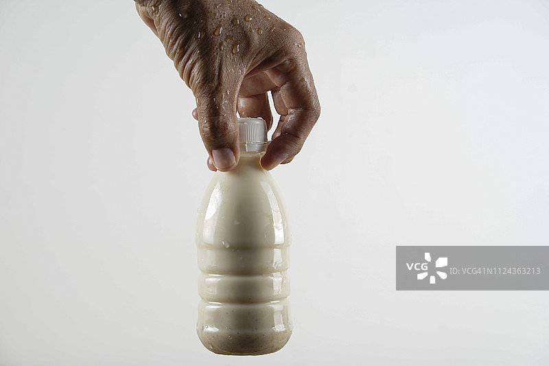 亚洲人拿着瓶装枣奶图片素材