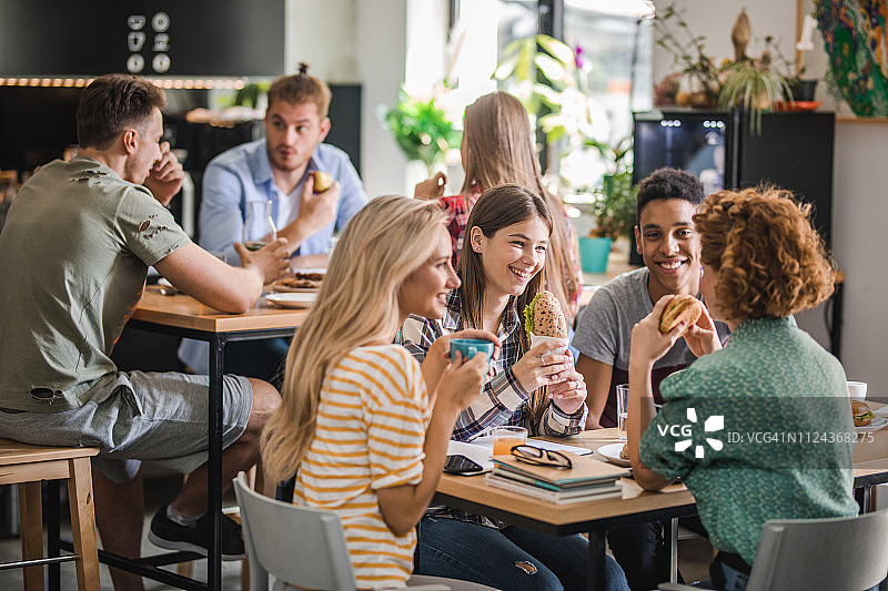在自助餐厅午休时交流的快乐大学生团体图片素材