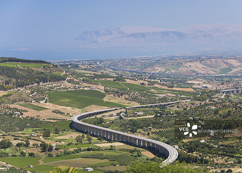 高速公路蜿蜒穿过塞格斯塔古城附近的农业景观，位于意大利西西里岛特拉帕尼图片素材